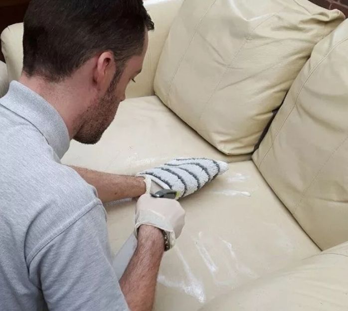 Мастер чистит диван из кожзама