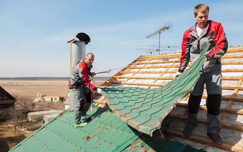 Рабочие демонтируют крышу из металлочерепицы